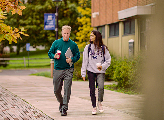 Penn State student Dhruvi Patel walking on campus with a professor